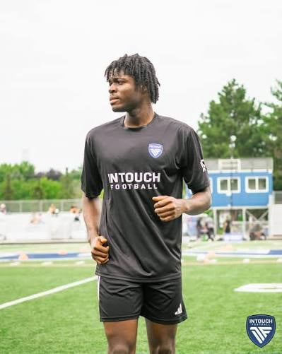Young athlete jogging on soccer field wearing black InTouch Football kit