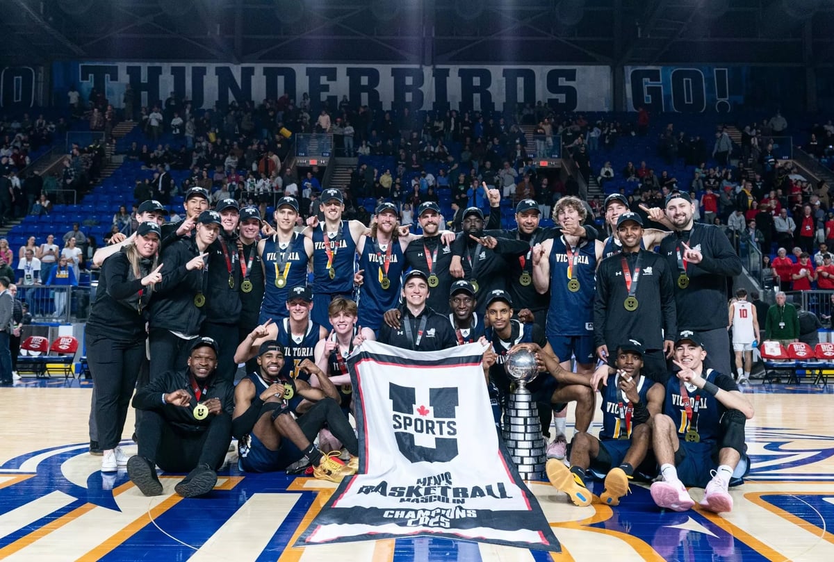 Thunderbirds basketball team celebrating championship victory on court with trophy and banner